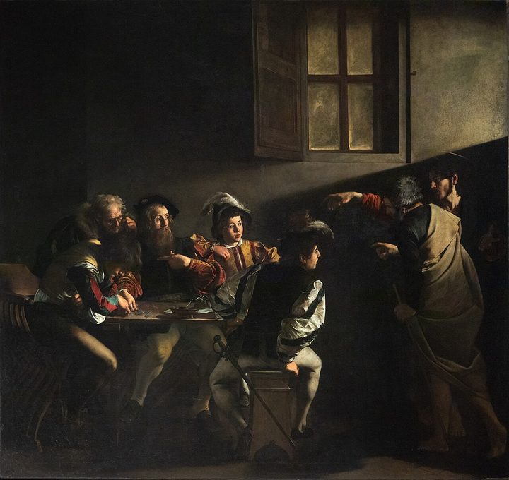 Men counting money at a table in a dark room, caught in a beam of light from a high window