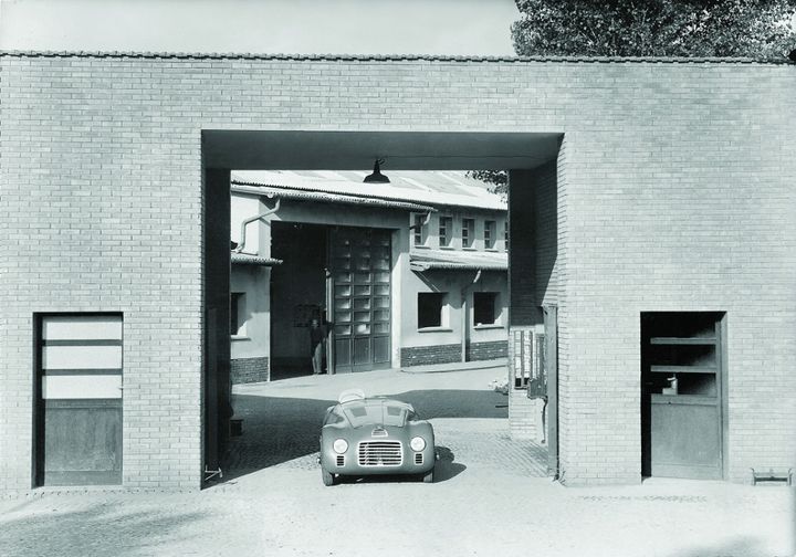 The first Ferrari, a 125 S, at the gate of the Maranello factory in 1947