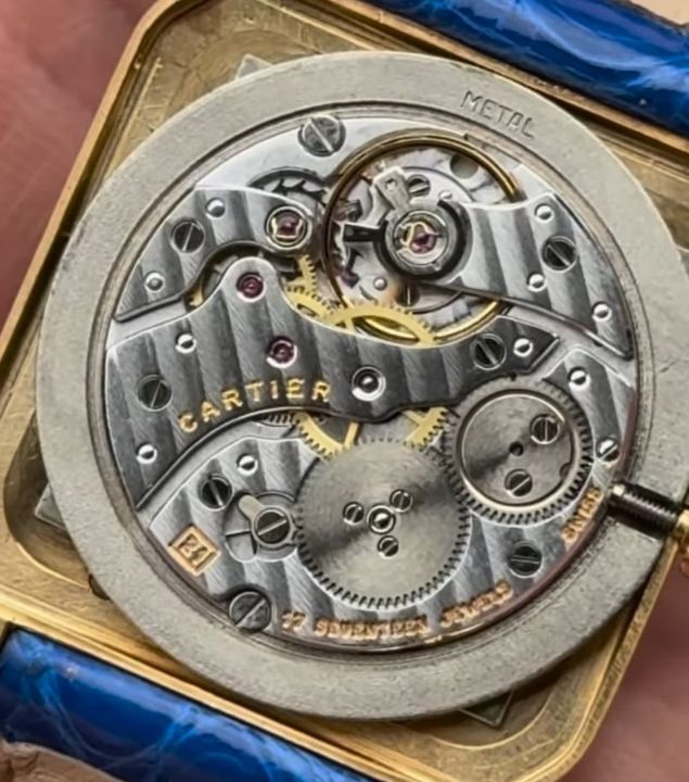 The hand-wound movement inside a Cartier Santos-Dumont, seen through the open case